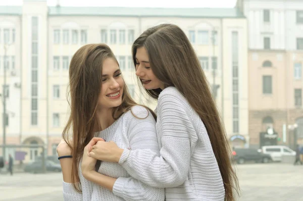 Two girlfriends are holding hands and fooling around in the city — Stock Photo, Image