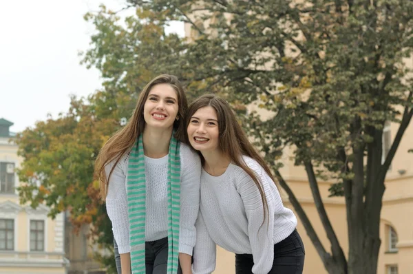 Duas namoradas estão rindo alegremente, abraçando um ao outro — Fotografia de Stock