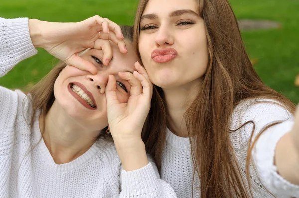Zwei Freundinnen werden getäuscht, indem sie Fratzen zeigen, während sie — Stockfoto