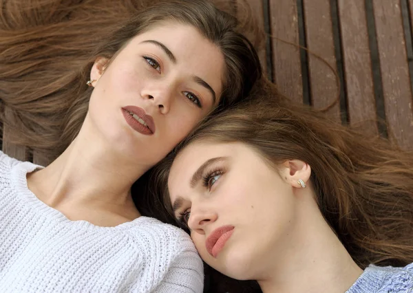 Close-up retrato de duas namoradas deitadas em um banco — Fotografia de Stock