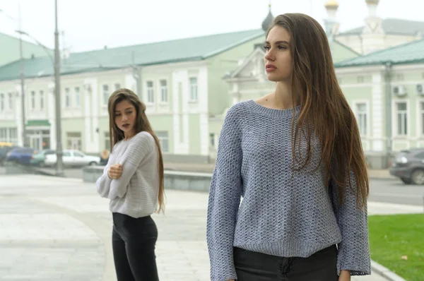 Two girlfriends quarreled, they stand at a distance and do not l Stock Picture