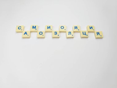 Beyaz bir arkaplanda, kelime harfleri olan Scrabble figürleri var: kendini izole etme. Kiril alfabesi, Rus alfabesi..