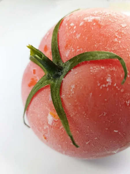 一个冷冻番茄特写 一只西红柿 白底上覆盖着白霜 白色背景上的西红柿的宏观照片 — 图库照片