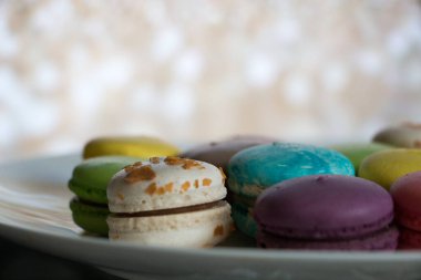 Beyaz tabakta renkli tatlı badem kurabiyeleri