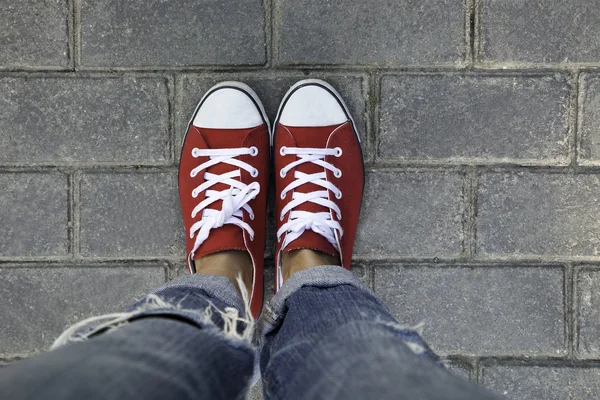 Kvinnor i röda sneakers på en gatsten trottoaren — Stockfoto