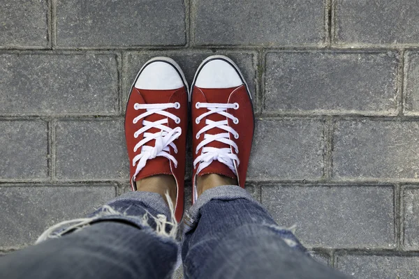Women in red sneakers on a paving stones pavement Stock Photo