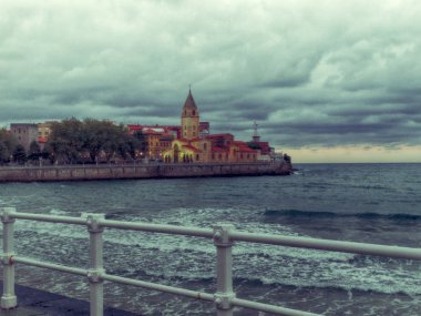 Gijon Santiago Apostol Kilisesi üzerinde denizin yanında dramatik bulutlar