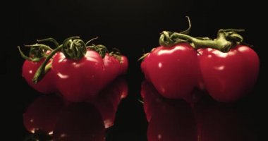 Taze kırmızı domates, merkez süper makro yakın plan, koyu arka plan, benzersiz yüksek çözünürlüklü 4k çekim.