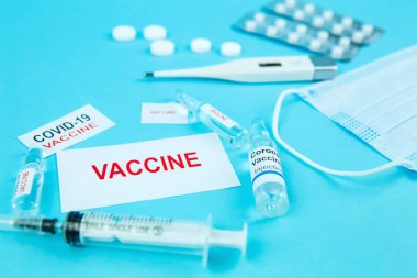 Coronavirus aşısı testi. İçinde ilaç, hap, şırınga, termometre ve maske olan şişeler. Mevsimsel grip ve nezle için bir tedavi. Covid-19 'un tedavisi için