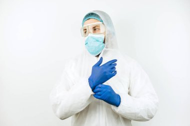 Hastanede vardiyadan sonra yorgun doktor portresi. Koruyucu giysili doktor. Gözlük, maske, beyaz arka planda eldivenler. Doktor koronavirüslü hastaları tedavi ediyor. Covid 2019