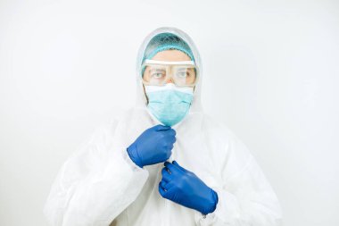 Hastanede vardiyadan sonra yorgun doktor portresi. Koruyucu giysili doktor. Gözlük, maske, beyaz arka planda eldivenler. Doktor koronavirüslü hastaları tedavi ediyor. Covid 2019
