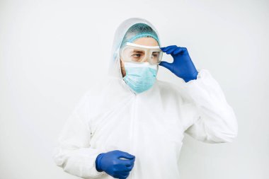 Hastanede vardiyadan sonra yorgun doktor portresi. Koruyucu giysili doktor. Gözlük, maske, beyaz arka planda eldivenler. Doktor koronavirüslü hastaları tedavi ediyor. Covid 2019