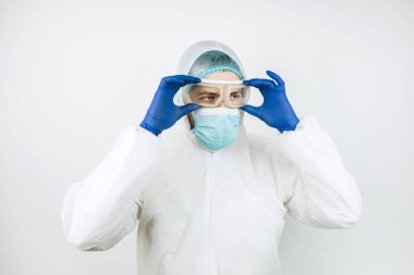 Hastanede vardiyadan sonra yorgun doktor portresi. Koruyucu giysili doktor. Gözlük, maske, beyaz arka planda eldivenler. Doktor koronavirüslü hastaları tedavi ediyor. Covid 2019
