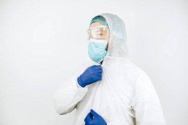Hastanede vardiyadan sonra yorgun doktor portresi. Koruyucu giysili doktor. Gözlük, maske, beyaz arka planda eldivenler. Doktor koronavirüslü hastaları tedavi ediyor. Covid 2019
