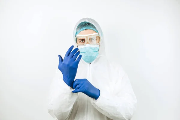 Hastanede vardiyadan sonra yorgun doktor portresi. Koruyucu giysili doktor. Gözlük, maske, beyaz arka planda eldivenler. Doktor koronavirüslü hastaları tedavi ediyor. Covid 2019