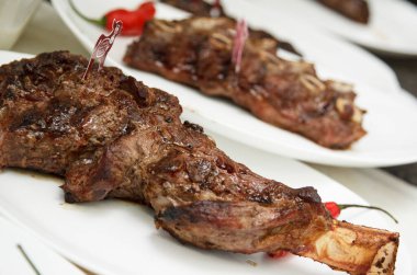 Kızarmış sığır kaburgası beyaz bir tabakta servis edilir.