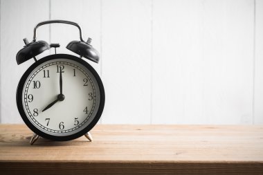 Ahşap masanın üzerinde klasik çalar saati olan sakin bir hayat (çalar saat 8 'i gösteriyor) )