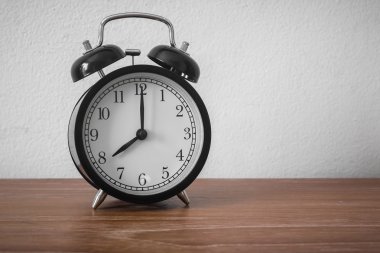 Ahşap masanın üzerinde klasik çalar saati olan sakin bir hayat (çalar saat 8 'i gösteriyor) )