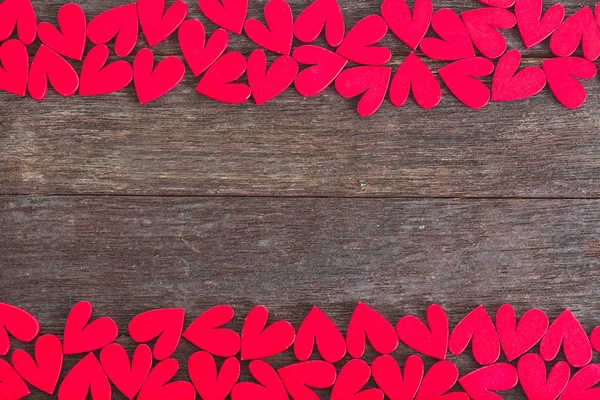 Ahşap arka planda kalpler tarafından yapılmış bir çerçeve