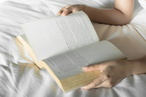 Mulher ler um livro na cama, foco seletivo — Fotografia de Stock