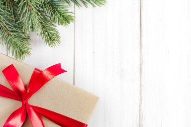 Kopya alanı metin için beyaz rustik ahşap zemin üzerine hediye kutusu ile Noel köknar ağacı dalları