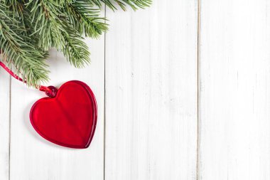 Beyaz köy ahşap zemin üzerinde kalp süsü olan köknar ağacı dalları ve metin için kopya alanı