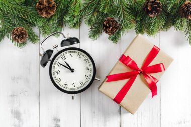 Noel ağacı dalları hediye kutusu ve alarm saati ile beyaz rustik ahşap zemin üzerinde metin alanı için kopyalanmış