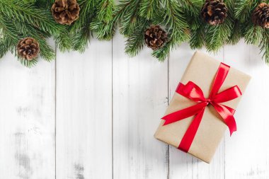 Kopya alanı metin için beyaz rustik ahşap zemin üzerine hediye kutusu ile Noel köknar ağacı dalları