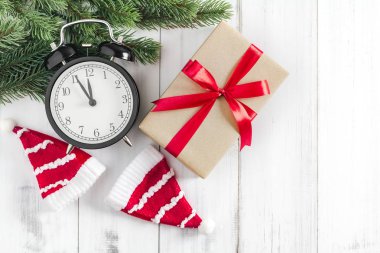 Noel ağacı dalları Noel Baba şapkası, hediye kutusu ve beyaz rustik ahşap zemin üzerinde alarm saati metin alanı için fotokopi alanı