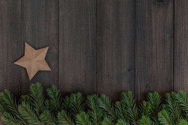 Noel köknar ağacı dalları ve metin için kopya yer karanlık rustik ahşap zemin üzerine yıldız kağıt