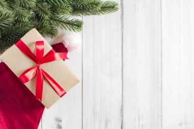 Noel ağacı dalları Noel Baba şapkası ve hediye kutusuyla beyaz rustik ahşap zemin üzerinde metin için kopya alanı ile birlikte.