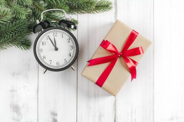 Noel ağacı dalları hediye kutusu ve alarm saati ile beyaz rustik ahşap zemin üzerinde metin alanı için kopyalanmış