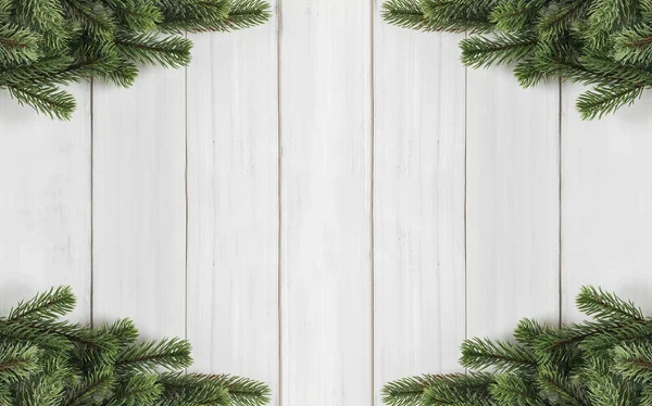 Christmas fir tree branches  on white rustic wooden background w