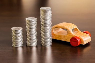 Ahşap masa üzerinde ahşap arabası olan bir yığın bozuk para.