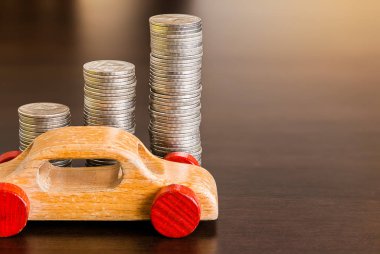 Ahşap masa üzerinde ahşap arabası olan bir yığın bozuk para.