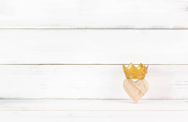 Drewniane serce w kształcie złotej korony na białym tle drewna — Zdjęcie stockowe