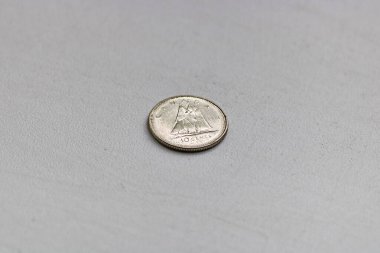 1981 'de yüzey değeri 10 Kanada senti olan beyaz metal madeni para. Üzerinde beyaz bir arka planda makro bir yelkenli resmi var.