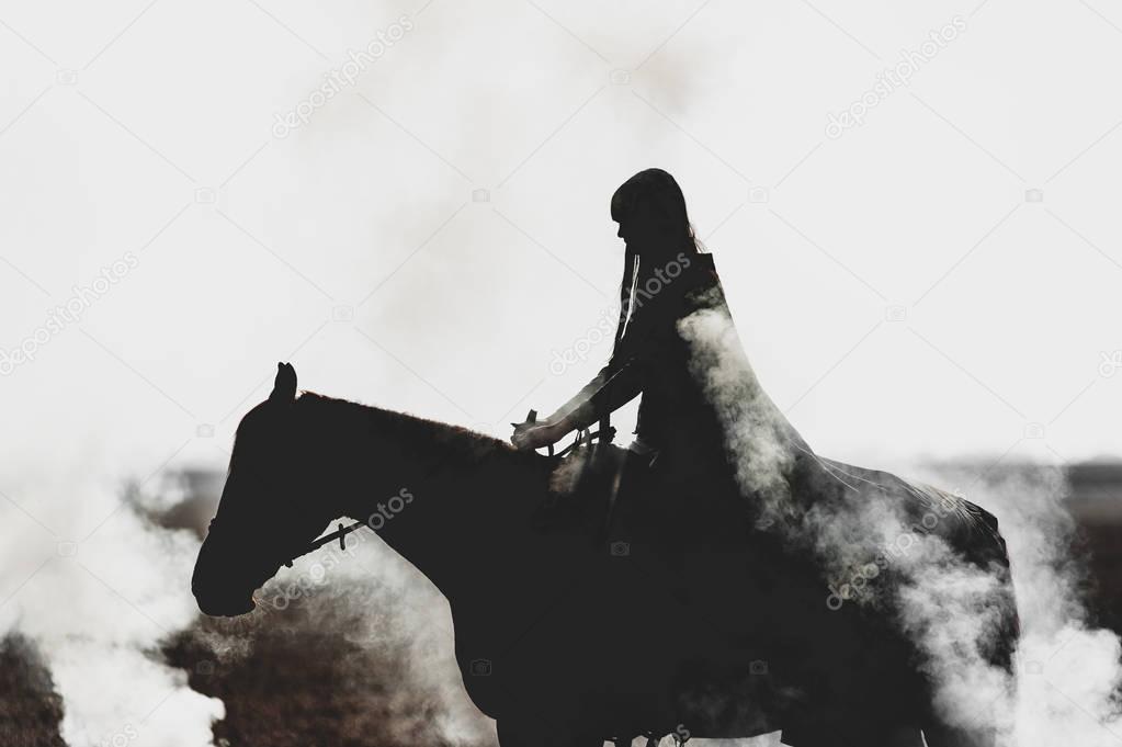 Beautiful silhouette of a girl who rides a horse through the thick smoke on a white background