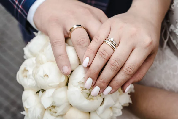 Trauringe Den Händen Eines Frischvermählten Auf Dem Hintergrund Eines Brautstraußes — Stockfoto