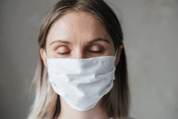 young girl with short hair in a white t-shirt in a mask, at home, close-up. Coronavirus. Quarantine