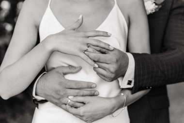 Nikah yüzüklü kadın ve erkeğin elleri. Düğün günü. Yeni evlilerin elinde altın yüzükler..