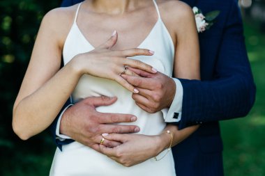 Nikah yüzüklü kadın ve erkeğin elleri. Düğün günü. Yeni evlilerin elinde altın yüzükler..