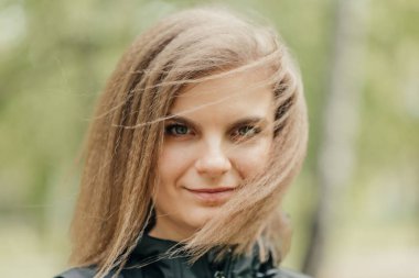 Gülümse. Açık havada buğday saçlı genç bir kız. Yakın plan. Kız gülümsüyor