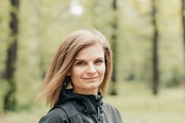 Gülümse. Açık havada buğday saçlı genç bir kız. Yakın plan. Kız gülümsüyor