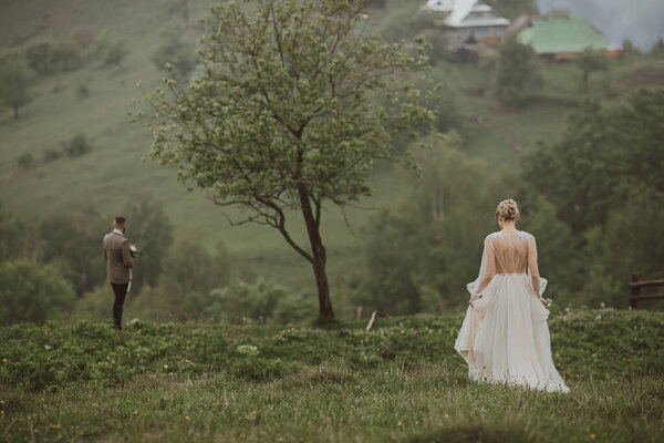 the bride goes to the groom, the first meeting of the bride and groom in the mountains, around fantastic nature, the bride in a beautiful dress