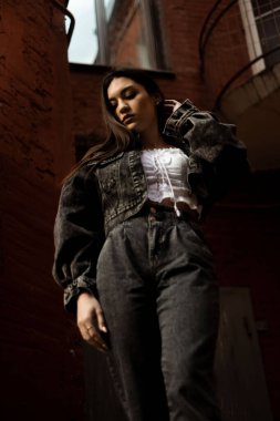 Duvara dayanmış bir kız, alt manzara.