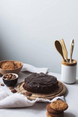 Kürsüde çikolatalı pasta ve beyaz arka planda kurabiyeler.