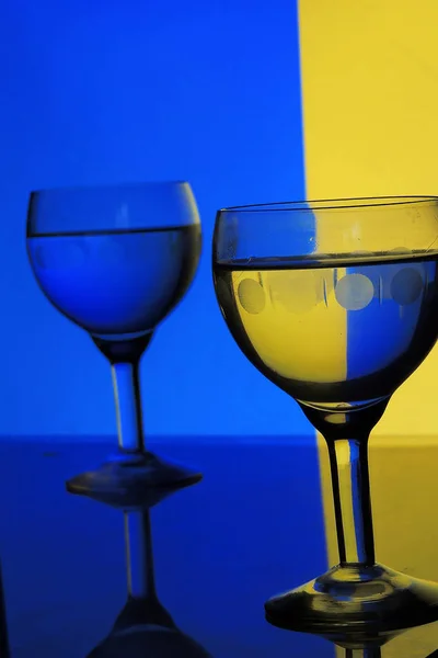 Pohár vizet a kék sárga háttér — Stock Fotó