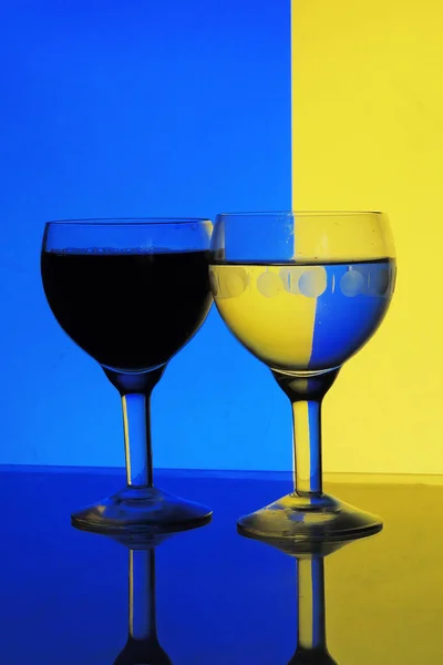 Glas vatten på blå gul bakgrund — Stockfoto