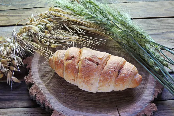 Croissant and spikelets of wheat — Stock Photo, Image